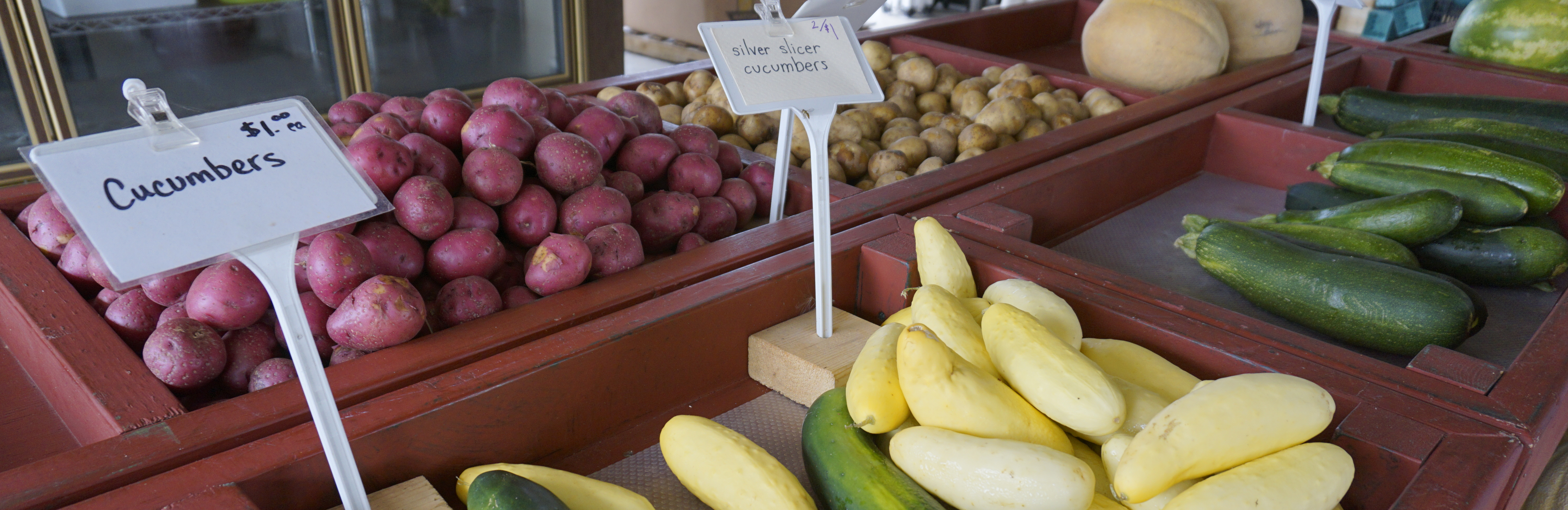 Cucumbers and potatoes at a farm stand